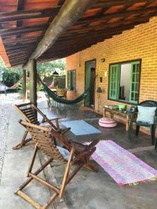 un patio con amaca e sedie e una casa di itamambuca condominio - Cabana Surf a Ubatuba