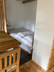 um pequeno quarto com uma cama e uma mesa em Fint sjönära annex em Växjö