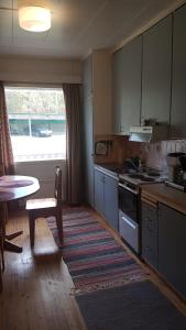 a kitchen with a table and a sink and a stove at Wanha Kaivoskylä Mainari Oy in Kemijärvi