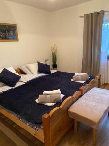 a bedroom with two beds with blue and white pillows at Kuća za odmor KOD DOZA in Gospić