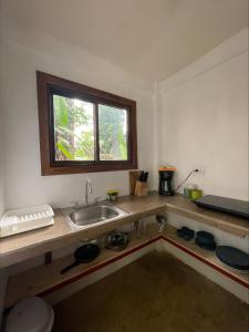 Casa Jaguar Tortuguero في تورتوجويرو: طاولة مطبخ مع حوض ونافذة