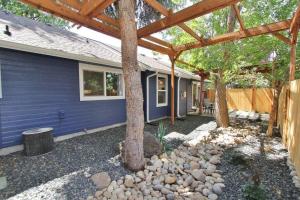een achtertuin met een blauw huis met een houten pergola bij Ocean Wave by Boise River + 2 Cruiser Bikes! in Boise