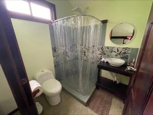 a bathroom with a shower and a toilet and a sink at Casa Jaguar Tortuguero in Tortuguero