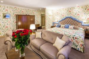 a bedroom with a bed and a couch and roses at Swiss Hotel in Lviv
