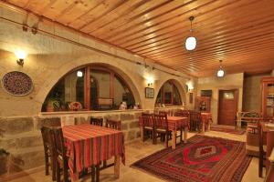 a restaurant with tables and chairs and a bar at Kemal's Guest House in Göreme