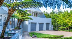 a white house with palm trees in front of it at TheLoft32 in Cape Town