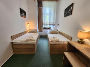 a room with two beds and a window at Pension City in Pilsen