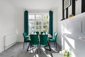 a dining room with a table and green chairs at Large 4 bed house Leicester in Leicester