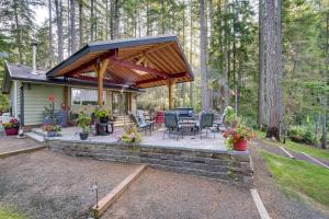 a house with a covered patio with a grill at Bremerton Vacation Rental with Hot Tub and Lake Access in Belfair