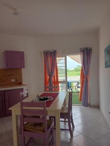 a kitchen with a table and chairs and a window at VIOLA in Vila do Porto