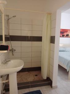 baño con lavabo y cama en VIOLA, en Vila do Maio