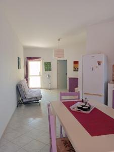 een woonkamer met een tafel en een koelkast bij VIOLA in Vila do Maio