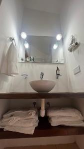 y baño con lavabo, espejo y toallas. en TRES CERRITOS SALTA en Salta