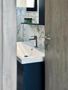 a bathroom with a white sink and a mirror at Alexandra's Place in Galatás