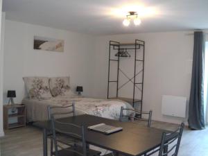 a bedroom with a bed and a table with chairs at Studio proche sortie autoroute in Noaillac