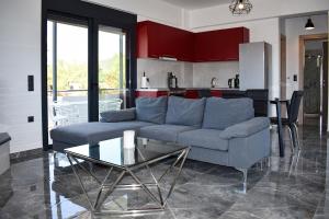a living room with a couch and a glass table at Alexandra's Place in Galatás