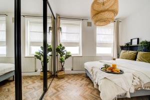 Un dormitorio con una cama y una mesa con fruta. en Beautiful 2bedroom close to Brick Lane, en Londres