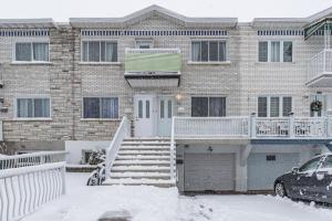 ein schneebedecktes Haus mit einem davor geparkt in der Unterkunft Free Parking Gorgeous 3Bedrooms in Montreal