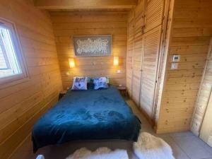 a bedroom with a bed in a wooden room at La joue du loup Bord des pistes - Chalet en bois de charme pour 10 personnes in Le Dévoluy