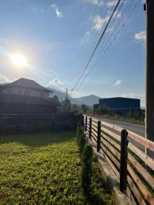 a fence next to a field next to a road at Casa Pietrele Doamnei in Câmpulung Moldovenesc