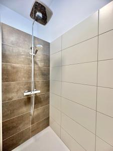 uma casa de banho com uma cabeça de chuveiro em Modernes City-Apartment mit Blick in den Park und 2 Bäder H9 em Oldenburg