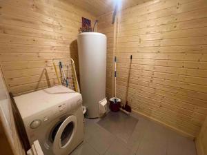 a bathroom with a washing machine in a wooden room at La joue du loup Bord des pistes - Chalet en bois de charme pour 10 personnes in Le Dévoluy