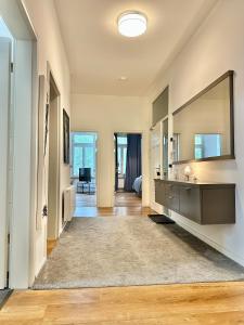 a bathroom with a sink and a large mirror at Modernes City-Apartment mit Blick in den Park und 2 Bäder H9 in Oldenburg