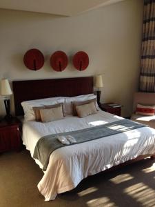 a bedroom with a large bed with two hats on the wall at Maropeng Boutique Hotel in Magaliesburg