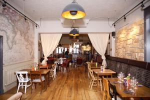 un restaurante con mesas y sillas de madera y una pared de ladrillo en The Captain Cook, en Londres