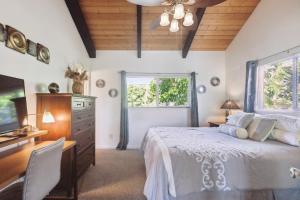 a bedroom with a bed and a desk and a television at Cozy Sunset Views with Lanai - Close to Beach home in Kailua-Kona