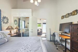 a bedroom with a bed and a desk and a television at Cozy Sunset Views with Lanai - Close to Beach home in Kailua-Kona