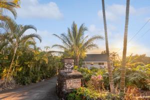 uma estrada com palmeiras e um edifício ao fundo em Cozy Sunset Views with Lanai - Close to Beach home em Kailua-Kona