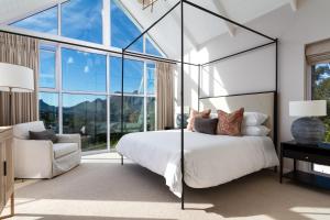a bedroom with a bed and a chair at Elite Retreats - Hillside Exclusive Villa 1 - load shedding backup in Cape Town