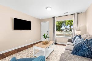 ein Wohnzimmer mit einem Sofa und einem TV in der Unterkunft New! Comfy Flat near Downtown Roseville in Roseville