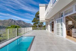 a house with a swimming pool and mountains in the background at Elite Retreats - Hillside Exclusive Villa 1 - load shedding backup in Cape Town