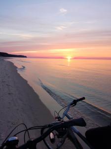 a bike parked on the beach at sunset at Domki na górce in Kołczewo