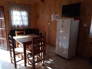 comedor con mesa y nevera en Cabaña La Perlita en Puerto Iguazú