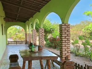 an outdoor patio with a table and brick columns at Pousada Flanboyan in São Miguel do Gostoso