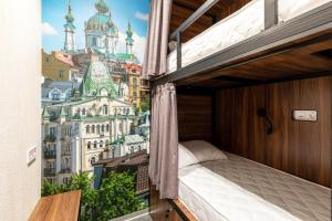 a bedroom with a view of the city at MISTO capsule hotel in Kyiv