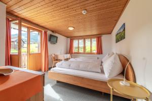 Schlafzimmer mit einem Bett mit Holzdecke in der Unterkunft Schwendi Lodge in Unterwasser