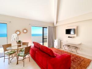 un soggiorno con divano rosso e tavolo di Hotel Palace 1 a Florianópolis