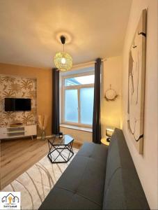ein Wohnzimmer mit einem Sofa und einem großen Fenster in der Unterkunft Luna Night Seh’Loué in Saint-Brieuc