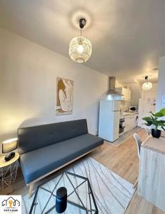 sala de estar con sofá azul y cocina en Luna Night Seh’Loué en Saint-Brieuc