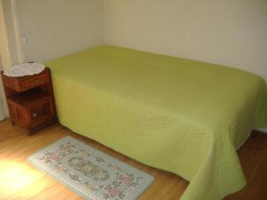 an unmade bed in a room with a wooden floor at Residência Ideal in Coimbra