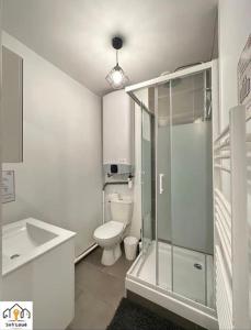 a bathroom with a toilet and a glass shower at Luna Night Seh’Loué in Saint-Brieuc