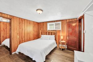 a bedroom with a bed and a wooden wall at Eagles Nest Motel Unit 2 in Escanaba
