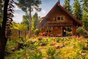 a wooden house with a garden in front of it at Cabana Mistic in Bran