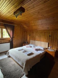 - une chambre avec un lit et un plafond en bois dans l'établissement Cabana Mistic, à Bran