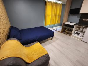 شقة دودي في لندن: غرفة نوم بسرير ازرق ومطبخ