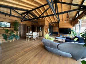 uma sala de estar com um sofá e uma sala de jantar em Eco Saguramo Chalet em Saguramo